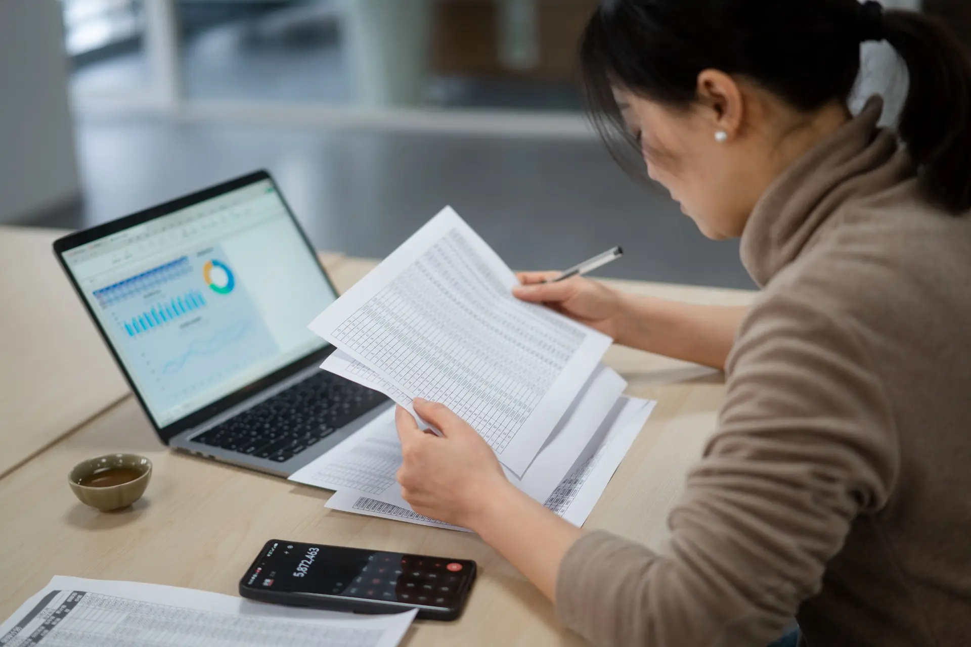 businesswoman reviewing accounts documents at desk