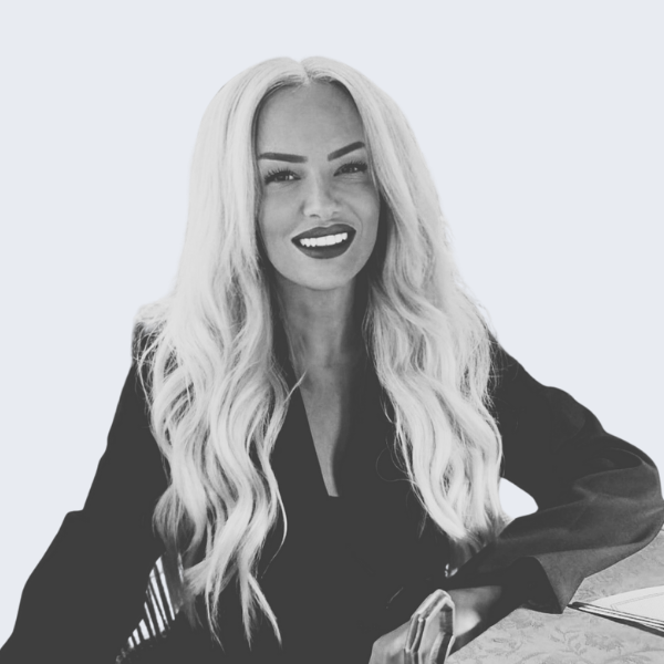 Photo shows a woman with long, wavy blonde hair, in a black top, smiling at the camera. Representing a recruitment agency near you, in Birmingham.