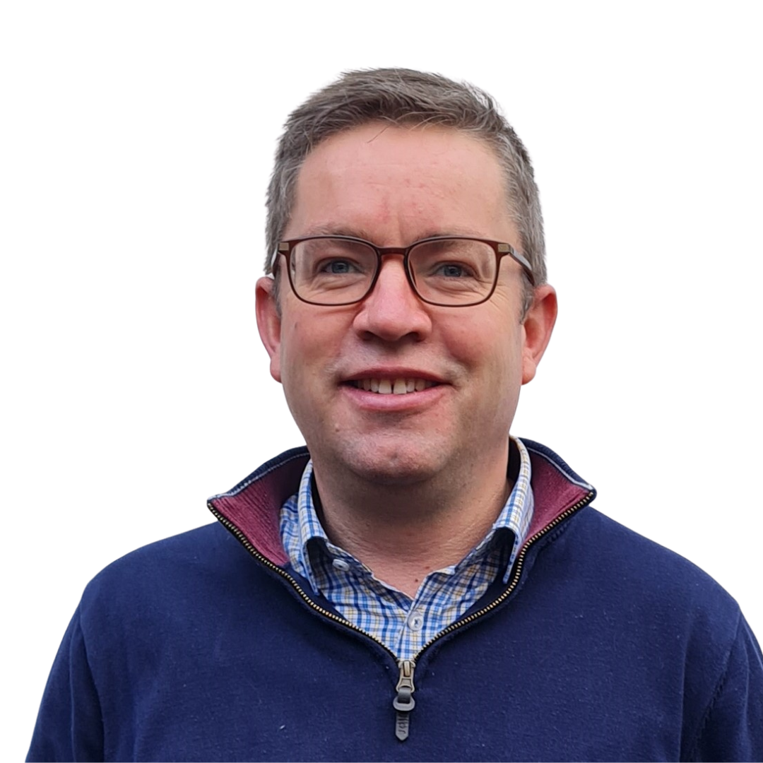 Warehouse worker standing in aisle arms crossed smiling to camera